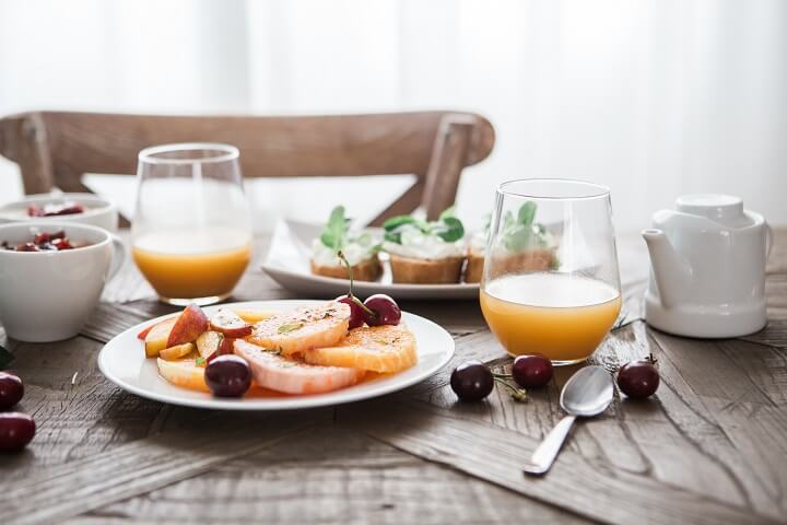 Bữa ăn sáng với dĩa trái cây và nước ép quả